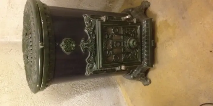 Vieux petit poêle céramique fonte