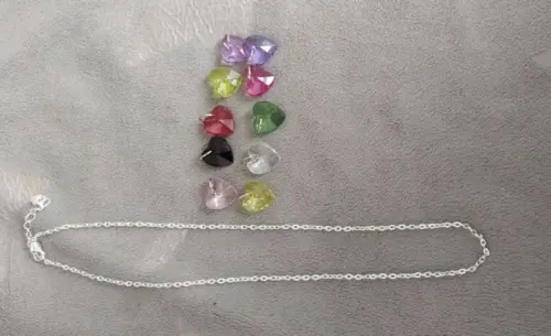 Collier + 10 pendentifs "coeurs" neufs à Moutier